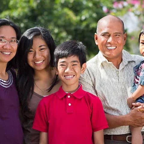 A Filipino family smiling together outdoors