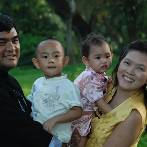 A Filipino couple holding their two children outdoors
